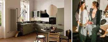 Moderne Wohnküche in sanften Grüntönen mit rundem Esstisch und großen Fenstern, daneben zwei Frauen, die auf einer Küchenbank zusammensitzen und bei Kaffee lächeln. Kombination aus Designküche und warmem Miteinander.